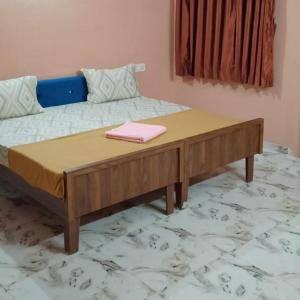 a bed with a wooden table in a room at Axar Complex (1BHK) in Anand