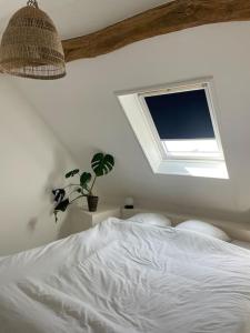 um quarto com uma cama branca e uma janela em Appartement cosy et lumineux au cœur de Montreuil em Montreuil-sur-Mer