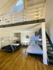 Pokój z 2 łóżkami piętrowymi i schodami w obiekcie TRIPLEX 8 COUCHAGES - BONASCRE AX LES THERMES w mieście Ax-les-Thermes