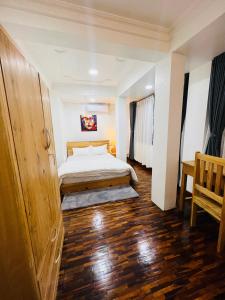 a bedroom with a bed and a wooden floor at Newa service apartment in Pātan