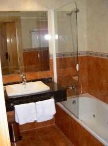 y baño con lavabo, bañera y ducha. en Manrique de Lara en San Leonardo de Yagüe