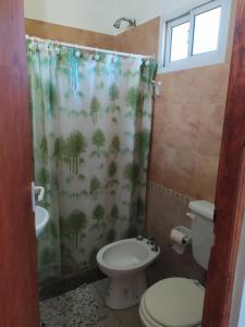 ein Badezimmer mit Toilette und Duschvorhang in der Unterkunft Deptos Peumayen - Parking - Excelente Ubicacion - Full Equipado in Río Colorado + 19 Fotos