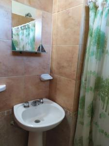 a bathroom with a sink and a mirror and a shower at Deptos Peumayen Familiar - Parking - Excelente Ubicacion - Full Equipado in Río Colorado +46 photos