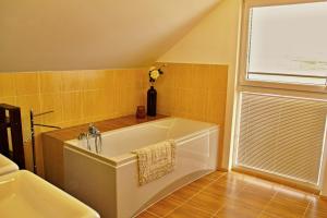 a bathroom with a bath tub with a vase of flowers at Private holiday house Vivendi in Liptovský Mikuláš