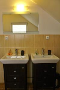 a bathroom with two sinks and a mirror at Private holiday house Vivendi in Liptovský Mikuláš