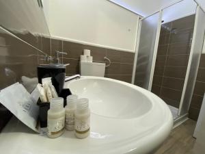 un lavandino in bagno con bottiglie di acqua ofodorizzatrici e specchio di Maestrale a Tertenìa Altre 20 foto