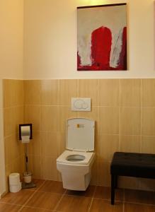 a bathroom with a toilet and a painting on the wall at Private holiday house Vivendi in Liptovský Mikuláš