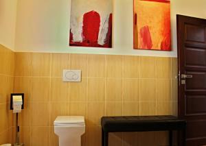 a bathroom with a toilet and paintings on the wall at Private holiday house Vivendi in Liptovský Mikuláš