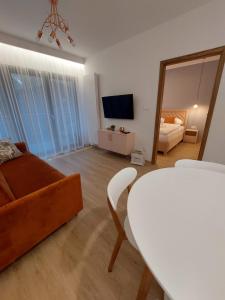 een woonkamer met een bank, een tafel en een spiegel bij Apartament Trójkąty i Kwadraty Karpatia Resort in Karpacz