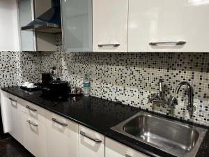 a kitchen with a sink and a black counter top at Yuhi Suites in Gurgaon