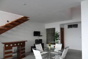 a dining room with a glass table and white chairs at Casa de Playa Akas in Canoas de Punta Sal