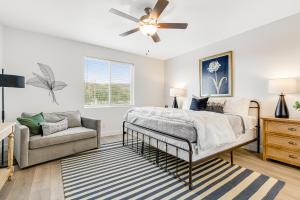 a bedroom with a bed and a couch and a ceiling fan at Grandma Buddy's House in Garden City