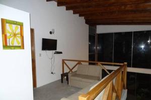 sala de estar con sofá y TV en Casa de Playa Akas, en Canoas de Punta Sal