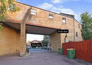 a brick building with two signs that say front door and park here at 2 Bed Functional House Close to Manor Park Train Station in London
