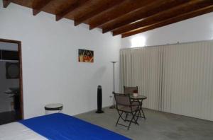 1 dormitorio con 1 cama, mesa y sillas en Casa de Playa Akas, en Canoas de Punta Sal