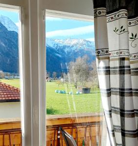 a window with a view of a field and mountains at Haus Moni in Bad Goisern