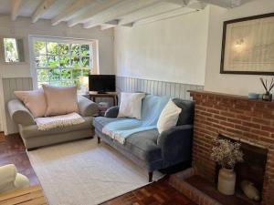 a living room with a couch and a fireplace at Peace Cottage in Whitstable