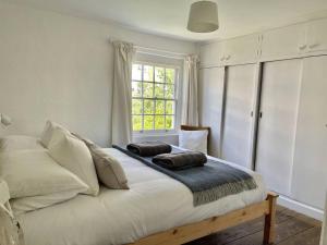 a bedroom with a bed with two pillows on it at Peace Cottage in Whitstable