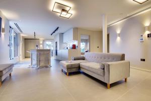 a living room with a couch and a kitchen at Luxury 3 bed flat with large terrace, sea views and hot tub in Canford Cliffs