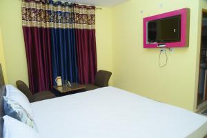 a hotel room with a bed and a tv at Indu BNB Shimla in Shimla