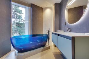 a large blue tub in a bathroom with a window at Luxury 3 bed flat with large terrace, sea views and hot tub in Canford Cliffs +40 photos