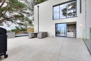 a patio with a table and chairs on a house at Luxury 3 bed flat with large terrace, sea views and hot tub in Canford Cliffs