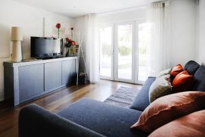 uma sala de estar com um sofá e uma televisão em Santa Joana Apartments with garden and heated pool em Lisboa