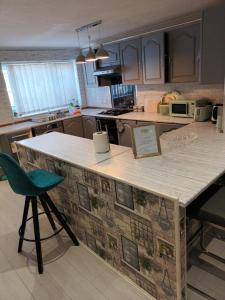 a kitchen with a counter and a green chair at Luxurious 4 bed adorable house in Willington in Willington