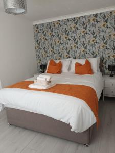 a bedroom with a large bed with orange pillows at Luxurious 4 bed adorable house in Willington in Willington
