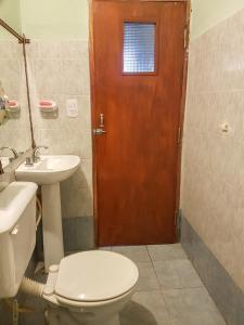 a bathroom with a toilet and a sink and a door at Lo del Gaucho in Tilcara