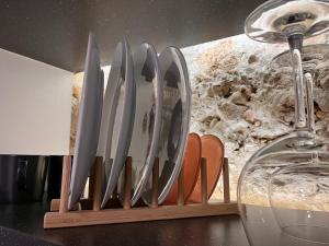 a row of knives in a wooden holder next to a wine glass at Oldtown apartment in Vilnius