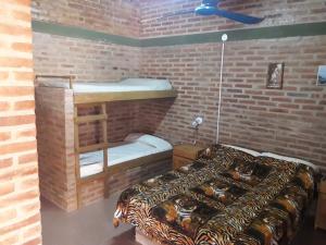 a room with a bed and a bunk bed at Posada Los Arcos in Villa Cura Brochero