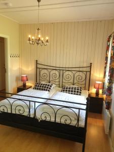 1 dormitorio con 1 cama negra grande y 2 lámparas en Valle Vandrarhem, en Axvall