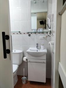 bagno bianco con servizi igienici e lavandino di V.V Casa Mones a Cangas de Onís