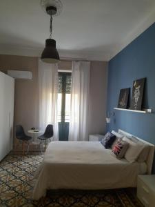 1 dormitorio con cama y pared azul en Lavilletta B&B, en Salerno