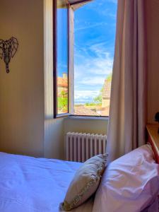 a bedroom with a bed and a window with a view at Hostellerie Du Chateau in Châteauneuf