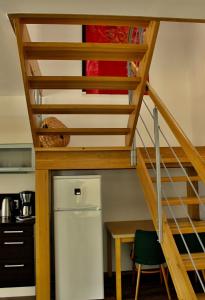 a staircase in a kitchen with a refrigerator and a table at Private holiday house Vivendi in Liptovský Mikuláš