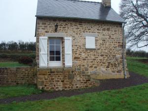 ein Backsteingebäude mit einem Seitenfenster in der Unterkunft Maison la Quentinière in Saint-Calais-du-Désert