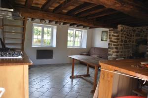 eine Küche mit einem Tisch und einem Sofa in einem Zimmer in der Unterkunft Maison la Quentinière in Saint-Calais-du-Désert