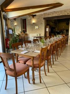 a long wooden table with chairs and wine glasses at Hostellerie Du Chateau in Châteauneuf