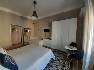 Un dormitorio con una gran cama blanca y una mesa en Lavilletta B&B, en Salerno