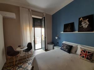 1 dormitorio con 1 cama, mesa y sillas en Lavilletta B&B, en Salerno