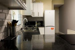 a kitchen with a white refrigerator and a sink at Large 4 Bed, En Suite Free Parking in Walton on the Hill