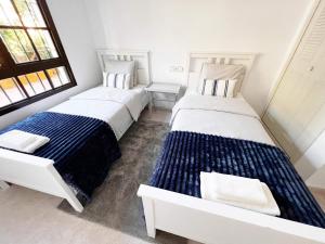 two twin beds in a room with two windows at Luxury Apartments Mascarat in Altea