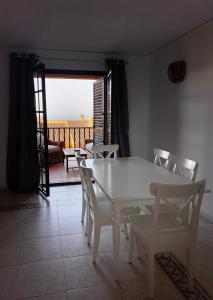 Una mesa blanca y sillas en una habitación con balcón. en Luxury Apartments Mascarat, en Altea