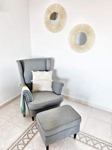 a chair and a stool in a room with a mirror at Luxury Apartments Mascarat in Altea