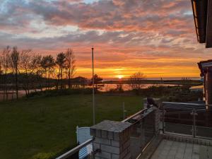 a view of a sunset from the balcony of a house at Heiligenhafen Doppel-Seeblick in Heiligenhafen