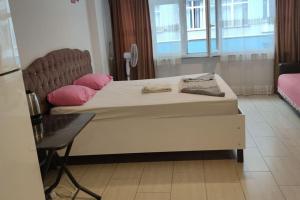 een groot bed met roze kussens in een kamer bij Midtown Hotel Apartments 202(0+1) in Istanbul