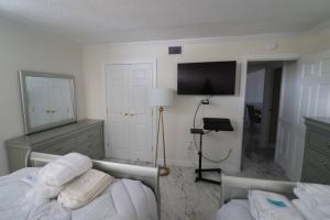 1 dormitorio con 1 cama y TV de pantalla plana en Ocean front best beach, boardwalk, dolphins!, en Virginia Beach
