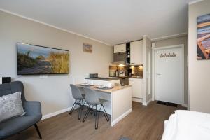 a living room with a table and chairs and a kitchen at Sylter Rose in Westerland (Sylt)